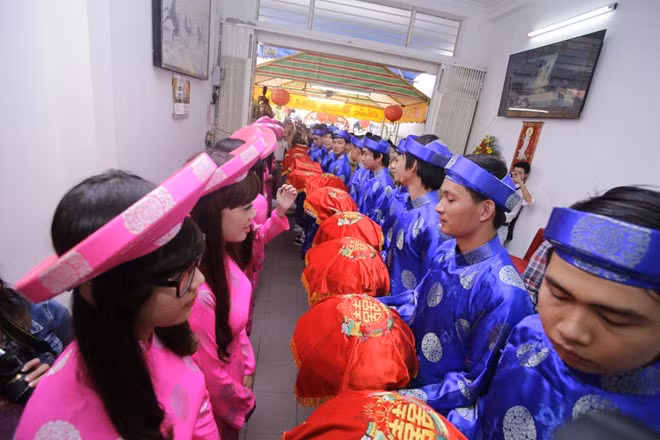 Đội hình bưng tráp trong lễ cưới của Thủy Tiên và Công Vinh gồm 11 chàng trai, cô gái. Trong khi các chàng trai diện áo dài xanh dương thì đội nhận tráp của nhà gái diện áo dài hồng. Những chiếc áo dài này được mẹ của nữ ca sĩ Kiss me thức khuya ủi tối qua.