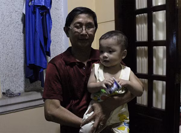 Bé trai được cán bộ phường bế trước giờ đến Trung tâm nuôi dưỡng bảo trợ trẻ em Tam Bình - Ảnh: Hải Hiếu