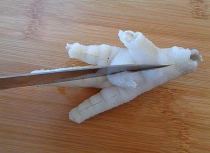 Bước 2: Dùng dao khứa trên từng ngón chân và khứa ở giữa chân gà như hình bên dưới.