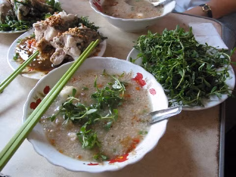 Cháo cá lóc rau đắng miền Tây: Món này được nấu từ gạo tẻ nở bung hạt, ninh kỹ, với thịt cá lóc, nấm rơm, chút tương, chút lạc, giá đỗ, hành, tiêu, rau thơm và đặc biệt là rau đắng đặc sản.