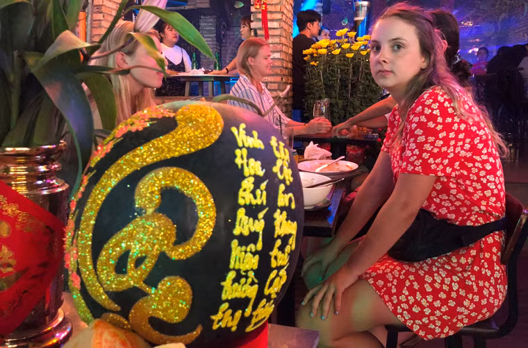 Nhóm du khách nước ngoài tỏ ra rất thích thú khi ngắm trái dưa hấu được khắc chữ đầy nghệ thuật.