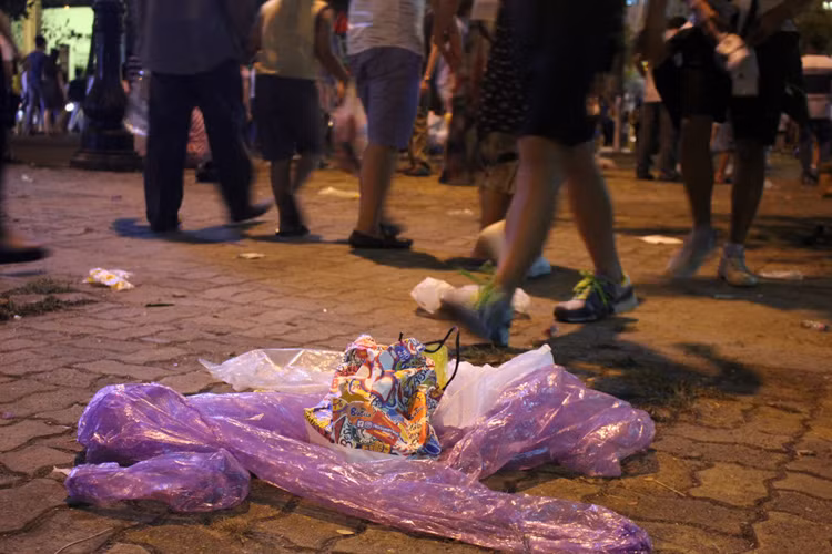 Người đi đường không mấy bận tâm đến rác thải dưới chân. Họ cứ thản nhiên bước đi trên phố.