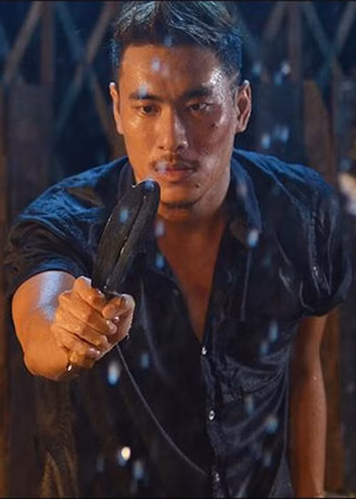 Kiều Minh Tuấn bắt đầu được khán giả chú ý hơn qua vai diễn “Tiến ngọng” - một tên du côn trong bộ phim điện ảnh “Bụi đời Chợ Lớn”. Đây là cây cười duy nhất trong bộ phim đầy bi thương, chết chóc. Ảnh: Thể thao văn hóa