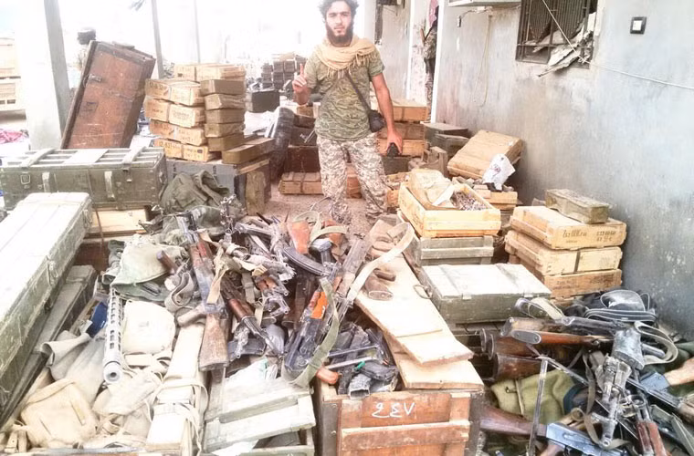 Ảnh: Chiến binh al-Nusra Font đứng cạnh kho vũ khí binh sĩ Quân đội Syria bảo vệ căn cứ.