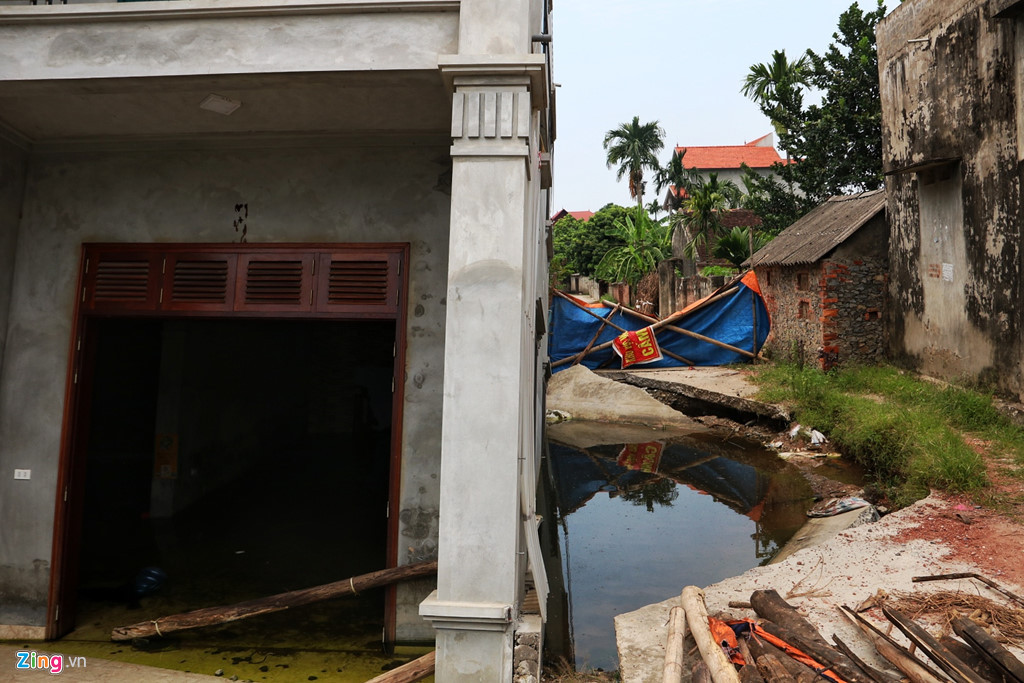 Sau nhiều đợt mưa, hố sụt bên hông căn nhà tạo thành một vũng nước lớn, sâu hơn 2 mét.