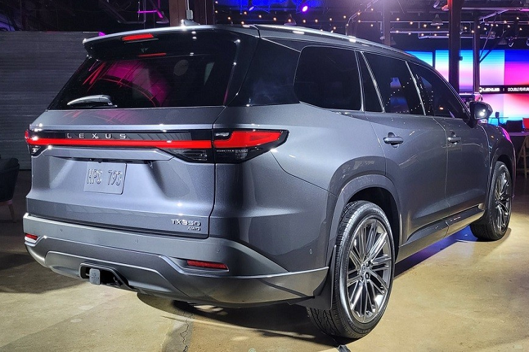 Bên sườn, Lexus TX 2024 không có nẹp màu đen ở hốc bánh hay sườn xe theo phong cách quen thuộc của các mẫu SUV. Tại đây, xe được trang bị đường dập gân kéo dài từ nắp ca-pô đến cột D và các loại vành la-zăng cỡ lớn. Trong khi đó, cản sau đi kèm ốp màu đen giúp xe trông cứng cáp hơn.