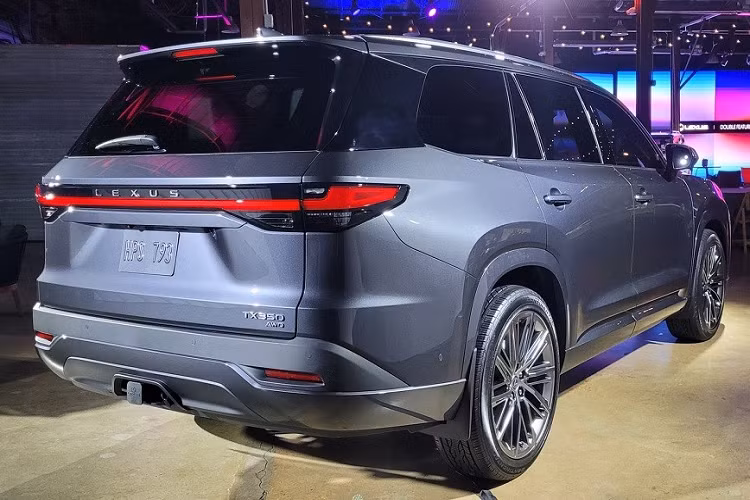 Bên sườn, Lexus TX 2024 không có nẹp màu đen ở hốc bánh hay sườn xe theo phong cách quen thuộc của các mẫu SUV. Tại đây, xe được trang bị đường dập gân kéo dài từ nắp ca-pô đến cột D và các loại vành la-zăng cỡ lớn. Trong khi đó, cản sau đi kèm ốp màu đen giúp xe trông cứng cáp hơn.