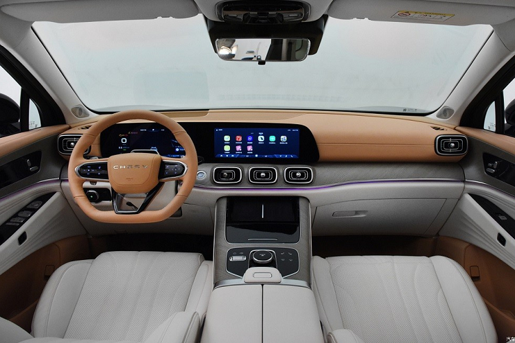 Bên trong Jaecoo 9 là không gian nội thất không khác gì Chery Tiggo 9. Nội thất của xe được bọc da phối 2 màu trẻ trung và ốp gỗ trên mặt táp-lô. Xe cũng đi kèm vô lăng vát đáy, tích hợp lẫy chuyển số và bảng đồng hồ kỹ thuật số gộp chung vào màn hình cảm ứng trung tâm. 