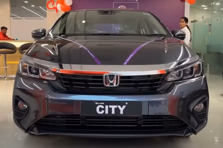 So với bản cao cấp, Honda City V 2023 mới sở hữu thiết kế ngoại thất khác biệt đáng kể. Theo đó, xe được trang bị các nan nằm ngang bên trong lưới tản nhiệt thay vì mắt lưới tổ ong như bản cao cấp. Nằm hai bên lưới tản nhiệt là cụm đèn pha projector với 3 bóng tách rời bằng vách hình chữ "L".