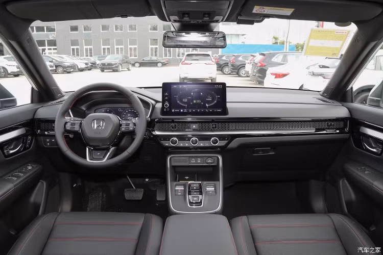 Bước vào trong xe, điểm thay đổi rõ nét hơn của chiếc xe Honda CR-V e:HEV đó là đã được thay thế lẫy chuyển số dạng nút bấm, đồng nhất với bản máy xăng là cửa gió điều hòa dạng tổ ong và màn hình điều khiển trung tâm dạng nổi.