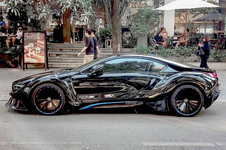 Bộ body kit thân rộng mang đến ngoại hình hầm hố cho xe với các vòm bánh xe được nới ra hết mức nhưng không sử dụng đinh tán giống như trên các mẫu độ của LBWorks mà được hoàn thiện liền khối. BMW i8 độ widebody được trang bị bộ mâm kích thước 21 inch thiết kế hai mảnh, sơn đen toàn bộ.