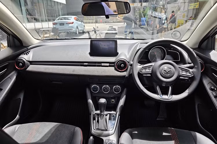 Thêm vào đó là những chi tiết màu cam Racing Orange ở cản trước, ốp gương chiếu hậu, vành la-zăng, đề-can bên sườn... Với phiên bản Clap Pop, Mazda2 2023 lại có những chi tiết sơn màu trắng như lưới tản nhiệt, ốp gương chiếu hậu, nóc và vành la-zăng. Trên nắp ca-pô, cản trước và cửa cốp có thêm họa tiết tòa nhà chọc trời, lấy cảm hứng từ quang cảnh đô thị.