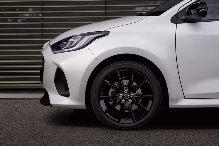 Tiếp theo đó là cản trước, vành la-zăng và cửa cốp mới. Bản cao cấp của xe sẽ dùng vành hợp kim 16 inch. Trong khi đó, 2 bản đắt nhất sẽ được trang bị vành 17 inch. Những chi tiết ngoại thất còn lại của Mazda2 Hybrid 2024 như cửa hai bên sườn, chắn bùn trước/sau, đèn pha, đèn hậu, nắp ca-pô, nóc và kính cửa sổ vẫn giống với Toyota Yaris.