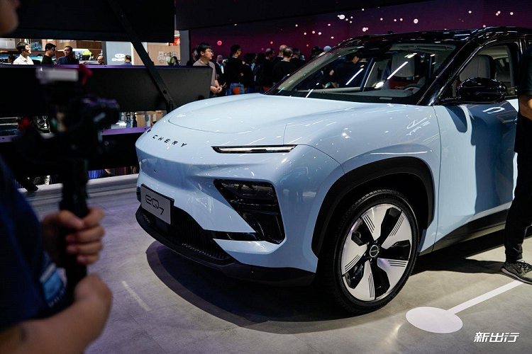 Ở bên sườn, Chery eQ7 sở hữu nóc dốc mượt mà về phía sau. Các cột và nóc đều được sơn màu đen, tạo hiệu ứng trôi nổi theo xu hướng. Đường chân kính của xe được thiết kế dốc dần lên ở cột C trong khi bên dưới là vành la-zăng 5 chấu khí động lực học. Tuy nhiên, không giống với nhiều mẫu ô tô điện đời mới khác, Chery eQ7 lại dùng tay nắm cửa thông thường thay vì loại nằm chìm vào thân xe.