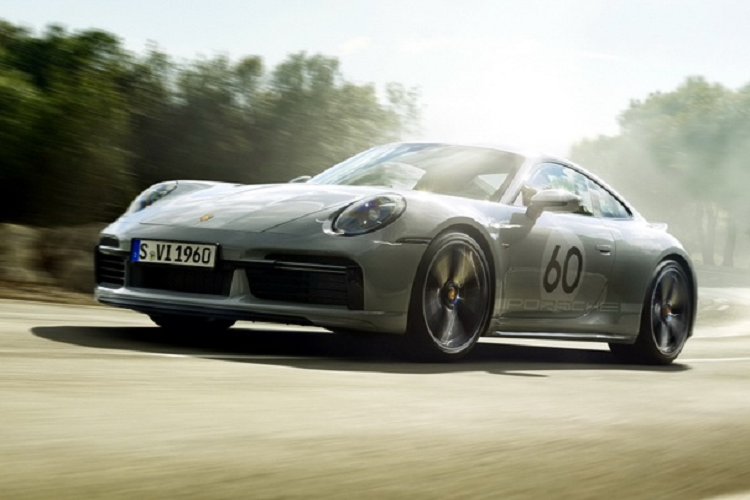 Bên trong khoang lái của xe Porsche 911 Sport Classic 2023 có dòng chữ 911 Sport Classic trên bậc cửa, ghế ngồi xe bọc da Cognac cổ điển sáng màu tương phản với họa tiết caro, các họa tiết Houndstooth cũng xuất hiện