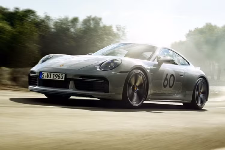 Bên trong khoang lái của xe Porsche 911 Sport Classic 2023 có dòng chữ 911 Sport Classic trên bậc cửa, ghế ngồi xe bọc da Cognac cổ điển sáng màu tương phản với họa tiết caro, các họa tiết Houndstooth cũng xuất hiện