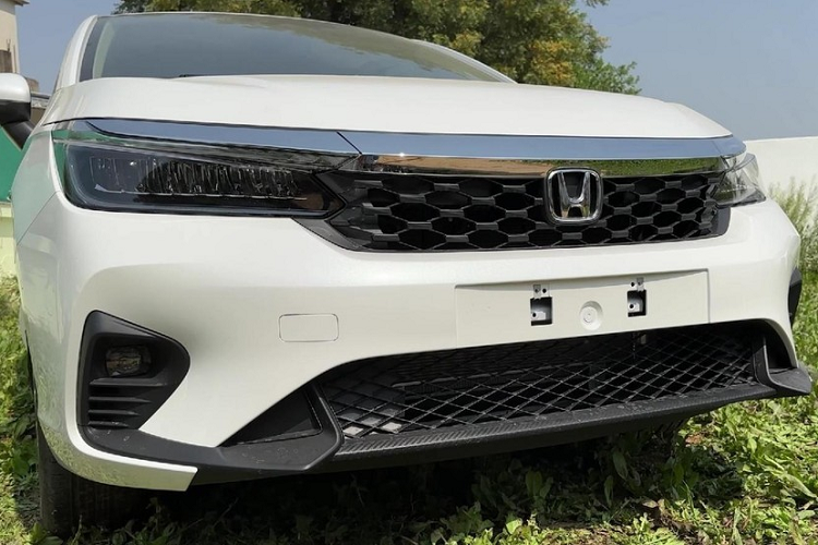 Có thể thấy rõ điều đó qua thiết kế đầu xe và vành la-zăng. Cụ thể, Honda City 2023 bản cao cấp sẽ được trang bị lưới tản nhiệt mới với mắt lưới hình tổ ong, cản trước thể thao hơn, tích hợp hốc đèn sương mù cải tiến ở hai góc. Hốc đèn sương mù này nối liền với hốc gió trung tâm thay vì tách rời như phiên bản cũ. Ngoài ra, hốc gió trung tâm của xe cũng được thiết kế rộng hơn và đi kèm lưới mắt cáo mới.
