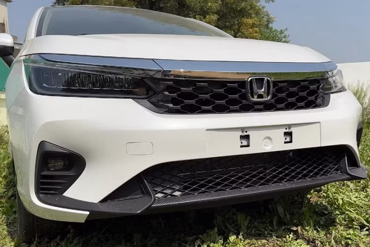 Có thể thấy rõ điều đó qua thiết kế đầu xe và vành la-zăng. Cụ thể, Honda City 2023 bản cao cấp sẽ được trang bị lưới tản nhiệt mới với mắt lưới hình tổ ong, cản trước thể thao hơn, tích hợp hốc đèn sương mù cải tiến ở hai góc. Hốc đèn sương mù này nối liền với hốc gió trung tâm thay vì tách rời như phiên bản cũ. Ngoài ra, hốc gió trung tâm của xe cũng được thiết kế rộng hơn và đi kèm lưới mắt cáo mới.