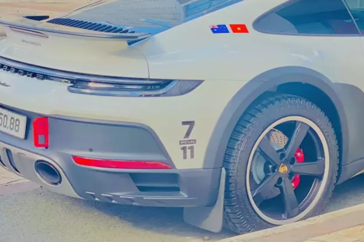 Chiếc xe thể thao giới hạn Porsche 911 Dakar đeo biển trúng đấu giá có ngoại thất sơn màu trắng cùng nhiều chi tiết sơn đen mờ như cản trước, sau, vòm bánh xe, la-zăng 5 chấu đơn cỡ lớn, cánh gió đuôi hay khuếch tán sau có tấm ốp inox sắc bén và kẹp phanh xe màu đỏ.