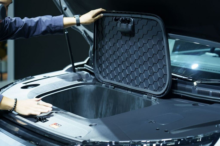 Trong khi đó, đèn pha của xe được đặt thấp bên dưới, trong hốc hình tam giác. Chiếc MPV này có nắp ca-pô được thiết kế khá phẳng, đi kèm logo của hãng. Dưới nắp capo này còn được trang bị một khoang hành lý nhỏ.