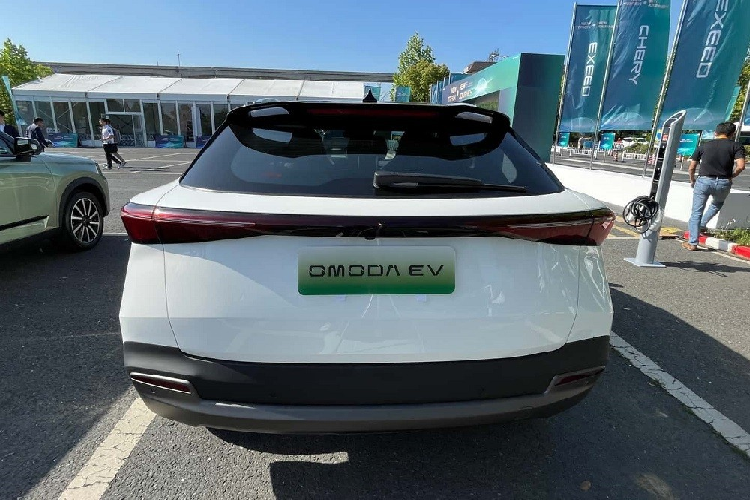 Đằng sau mẫu xe điện này xuất hiện cản va đơn giản hơn và không có 2 đầu ống xả giả mạ crôm như phiên bản máy xăng. Những chi tiết thiết kế còn lại của OMODA 5 e-QUA tương đối giống phiên bản máy xăng, từ hệ thống đèn 2 tầng trên đầu xe, nóc, đường chân kính, tay nắm cửa, cụm đèn hậu nằm vắt ngang đuôi xe đến cánh gió mui...