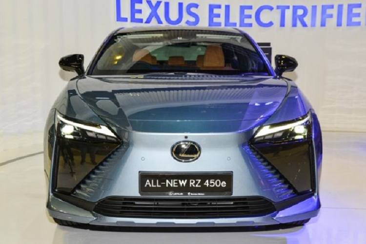 Ở phần đầu xe, SUV điện Lexus RZ450e vẫn có tạo hình mặt ca-lăng với bộ lưới tản nhiệt giả hình con suốt quen thuộc. Bề mặt lưới tản nhiệt được làm nhẵn, trong khi các cạnh bên là những đường gờ đẹp mắt nhấn mạnh vào kiểu thiết kế hình con suốt đã đi theo Lexus từ rất lâu. Nằm đối xứng hai bên vẫn là cụm đèn pha vuốt nhọn đầy sắc sảo kết hợp cùng nắp capo dập nổi nhẹ nhàng làm tăng thêm vẻ tinh tế và cá tính cho “khuôn mặt” của RZ 50e.