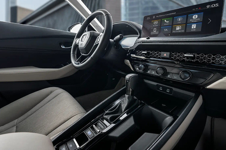 Bên trong Honda Accord 2024 là không gian nội thất rộng rãi hơn nhờ chiều dài tăng 69 mm. Nội thất xe cũng khá giống với 2 người anh em CR-V và Civic mới. Điều này được thể hiện rõ qua cửa gió điều hòa nằm bên dưới tấm lưới tổ ong kéo dài trên mặt táp-lô.