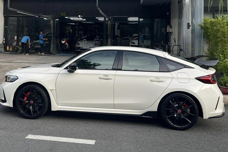 Khác với chiếc xe của Cường Đô la, xe đua đường phố Honda Civic Type R 2023 thứ 2 tại Việt Nam bàn giao cho chủ nhân có ngoại thất màu trắng với nhiều chi tiết sơn đen như la-zăng 19 inch, vỏ gương, viền cửa, cánh gió đuôi, cản trước/sau và lưới tản nhiệt.