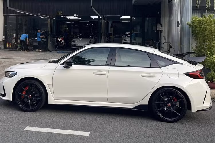 Khác với chiếc xe của Cường Đô la, xe đua đường phố Honda Civic Type R 2023 thứ 2 tại Việt Nam bàn giao cho chủ nhân có ngoại thất màu trắng với nhiều chi tiết sơn đen như la-zăng 19 inch, vỏ gương, viền cửa, cánh gió đuôi, cản trước/sau và lưới tản nhiệt.