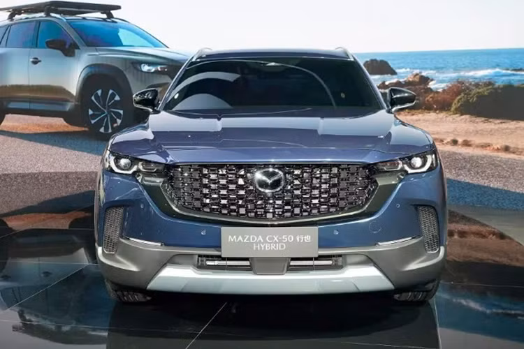 Đầu xe gây ấn tượng với lưới tản nhiệt màu đen, được bao bởi đường viền dày dặn cùng màu giúp mẫu xe SUV Mazda CX-50 Hybrid trông mạnh mẽ và thể thao hơn. Nối liền với lưới tản nhiệt là cụm đèn pha LED tạo hình tròn trịa, tích hợp dải đèn LED định vị ban ngày.