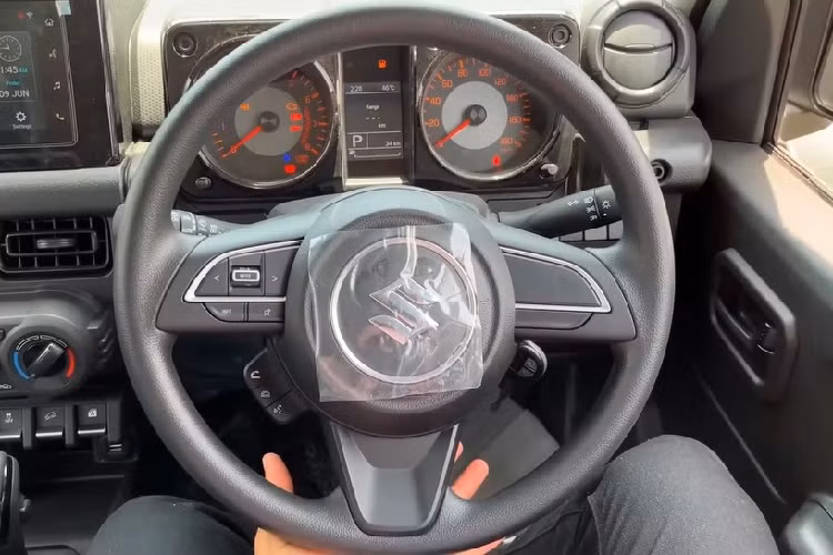 Đằng sau Suzuki Jimny Zeta 5 cửa là cụm đèn hậu nằm trên cản sau và dùng bóng Halogen thông thường. Thêm vào đó là ăng ten thanh que, cửa cốp mở ngang sang bên phải, cần gạt nước/rửa kính sau và sấy kính sau. 