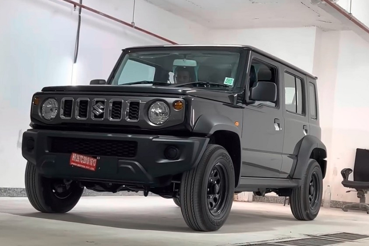 Phía sườn của xe, Suzuki Jimny 5 cửa bản Zeta chỉ được trang bị vành thép 15 inch, sơn màu đen. Trên chắn bùn trước còn có thêm đèn báo rẽ nhỏ trong khi gương chiếu hậu chỉ có tính năng chỉnh điện.