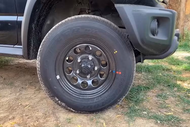 So với bản cao cấp Alpha (xe màu trắng), Suzuki Jimny 5 cửa bản tiêu chuẩn thiếu những trang bị như đèn pha LED với hệ thống rửa đèn và tính năng tự động bật/tắt, đèn sương mù trước, kính ngăn tia cực tím UV, gương chiếu hậu gập điện/chỉnh điện hay vành hợp kim 15 inch.