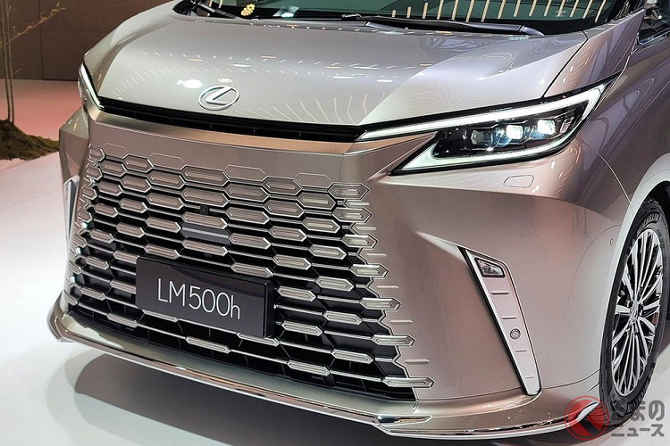 Bên trên lưới tản nhiệt còn có thêm một khe gió hẹp nằm giữa 2 đèn pha. Bản thân cụm đèn pha của Lexus LM 2023 cũng được làm mới thiết kế. Cụm đèn pha với 3 bóng LED này vẫn có thiết kế sắc sảo như trước nhưng đi kèm 2 dải đèn LED định vị ban ngày hình chữ "L" thay vì 1 như thế hệ cũ. Trong khi đó, logo của hãng Lexus đã được chuyển từ bên trong lưới tản nhiệt lên trên nắp ca-pô. Ở hai góc cản trước có thêm khe gió nằm dọc, trang trí bằng nẹp màu bạc cứng cáp hơn.