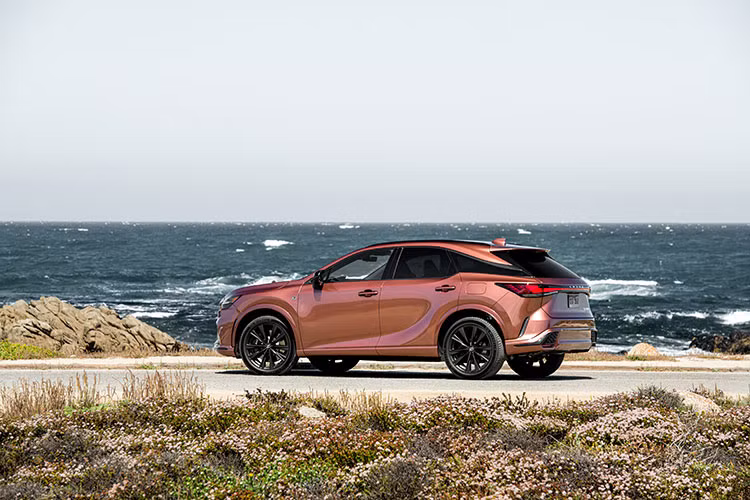 Tổng thể Lexus RX 2023 tại Việt Nam chắc chắn nhờ chiều dài cơ sở được kéo dài hơn 60mm so với phiên bản cũ. Thiết kế bên hông cuốn hút nhờ tạo hình trực quan với vòm bánh xe mở rộng sang hai bên (+25mm) kết hợp cùng mâm xe 21-inch.