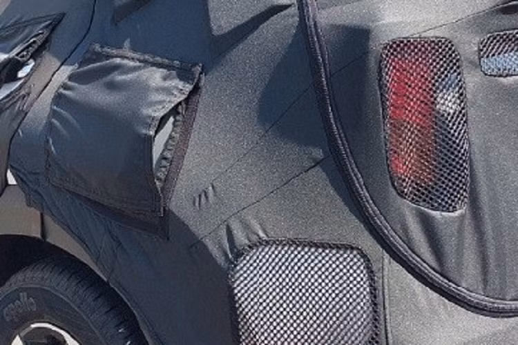 Bên dưới là cản trước mới, tích hợp hốc gió trung tâm có vẻ rộng hơn trước. Khu vực bên sườn của Kia Sonet 2024 dự kiến sẽ không thay đổi về thiết kế, trừ vành la-zăng. Chiếc xe chạy trên đường thử được trang bị vành hợp kim đa chấu, phay xước 2 màu. Đằng sau, Kia Sonet 2024 được bổ sung cụm đèn hậu LED hình chữ "L" mới.