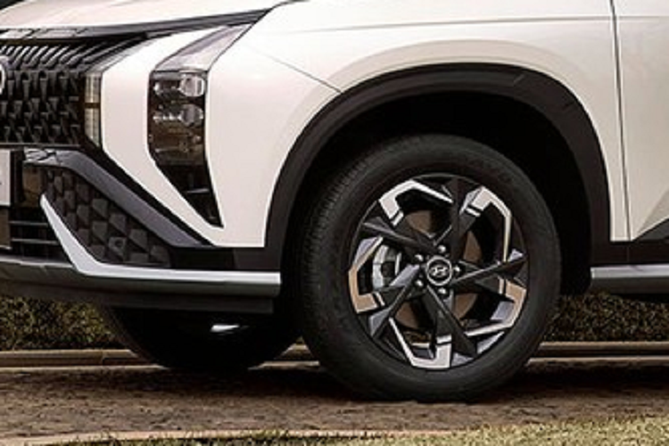 Điểm nhấn tiếp theo trong thiết kế của Hyundai Mufasa là cản trước thể thao, tách rời với lưới tản nhiệt bằng nẹp màu đen bóng. Trên cản trước còn có hốc gió trung tâm hình thang, nằm giữa 2 tấm ốp nhựa với thiết kế hình học. Chính giữa hốc gió trung tâm là hộp chứa các cảm biến, hỗ trợ hệ thống trợ lái nâng cao ADAS của xe.