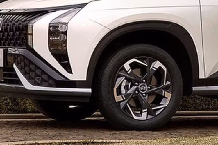 Điểm nhấn tiếp theo trong thiết kế của Hyundai Mufasa là cản trước thể thao, tách rời với lưới tản nhiệt bằng nẹp màu đen bóng. Trên cản trước còn có hốc gió trung tâm hình thang, nằm giữa 2 tấm ốp nhựa với thiết kế hình học. Chính giữa hốc gió trung tâm là hộp chứa các cảm biến, hỗ trợ hệ thống trợ lái nâng cao ADAS của xe.