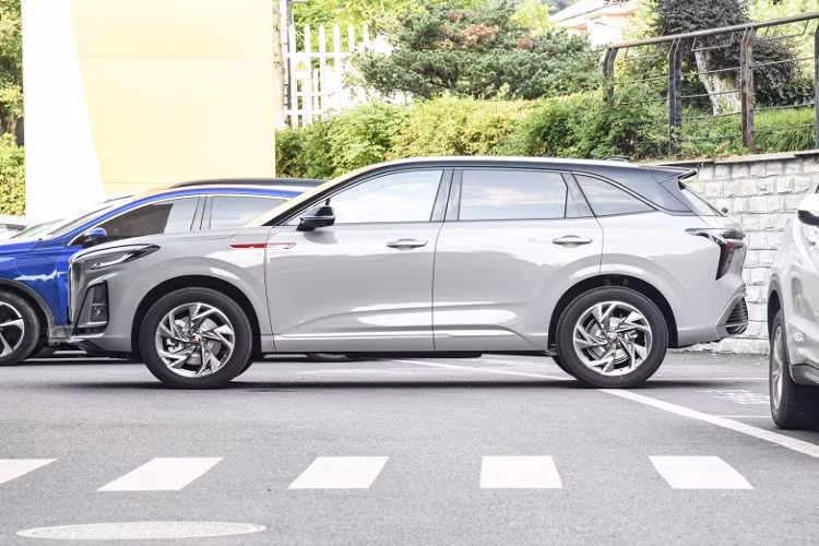 Trong đó, SUV Hồng Kỳ HS3 2023 vẫn tiếp tục chủ đề thiết kế của đôi cánh bay nhà Hồng Kỳ. Điều này thể hiện rõ nhất qua lưới tản nhiệt hút gió phía trước hình vuông có kích thước rất phóng đại, trong khi đó, các nan lưới được trang trí bằng lớp mạ crôm thẳng hình thác nước, kết hợp cùng các đường cờ đỏ được kết nối khéo léo với lưới tản nhiệt kéo dài đến nắp động cơ, cho hiệu ứng hình ảnh độc đáo.