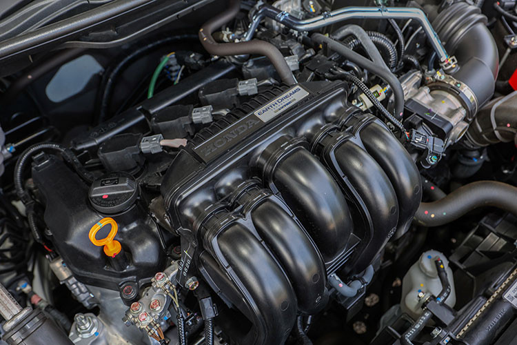 Nằm bên dưới nắp ca-pô của Honda City 2023 là 2 tùy chọn động cơ. Thứ nhất là động cơ xăng 4 xi-lanh, hút khí tự nhiên, dung tích 1.5L, sản sinh công suất tối đa 121 mã lực và mô-men xoắn cực đại 145 Nm. Động cơ này kết hợp với hộp số sàn 6 cấp hoặc hộp số biến thiên vô cấp CVT.