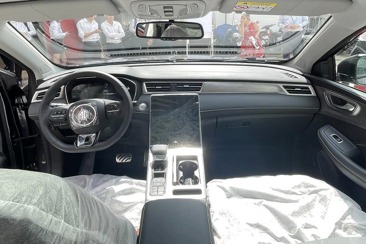 Bên trong MG RX5 là không gian nội thất 2 hàng ghế với 5 chỗ ngồi. Hình ảnh chụp tại đại lý cho thấy mẫu SUV cỡ C này sở hữu ghế bọc da phối 2 màu trong khi mặt táp-lô ốp giả gỗ. Trước mặt người lái là vô lăng vát đáy thể thao, tích hợp phím chức năng và bảng đồng hồ kỹ thuật số 12,3 inch.