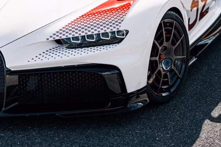 Mảng màu đỏ này dần chuyển dịch từ khối màu sang hình chấm rồi trở thành biểu tượng “EB” (viết tắt tên nhà sáng lập Ettore Bugatti) và nhỏ dần đồng thời chuyển lại về màu đen. Điều tương tự cũng được lặp lại ở phần đuôi xe và cánh lướt gió cỡ lớn.