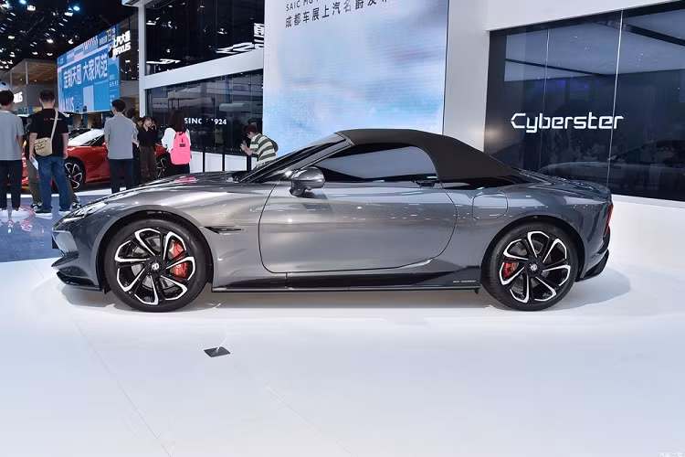 Trên cửa còn có cảm biến để phát hiện vật cản phía trên và hai bên sườn để ngăn va chạm khi mở cửa. Chưa hết, MG Cyberster còn có chắn bùn "cơ bắp", mui nỉ có thể đóng/mở, phanh Brembo với cùm phanh cố định 4 piston sơn màu đỏ, cụm đèn hậu mỏng nằm vắt ngang đuôi xe, đèn báo rẽ hình mũi tên tích hợp vào khe gió và bộ khuếch tán gió thể thao dưới cản sau.