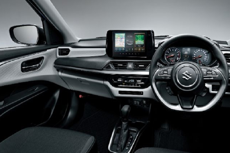 Chiếc Suzuki Swift 2024 trong hình ảnh do hãng tung ra được sơn màu xanh dương với nóc đen tương phản. Trên nóc vẫn là ăng ten dạng cột như thế hệ cũ. Bên trong xe cũng được thổi làn gió mới, với những trang bị hiện đại hơn như màn hình hiển thị thông tin kính lái HUD, màn hình cảm ứng trung tâm 9 inch, điều hòa tự động 1 vùng và cổng USB. 