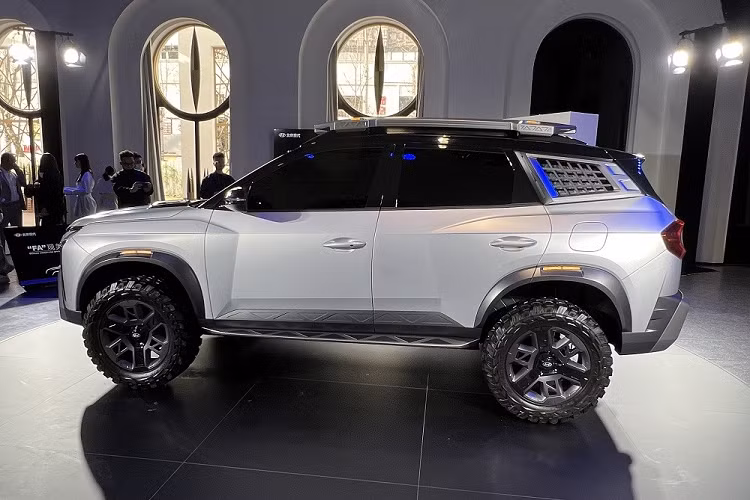 Điểm nhấn đập vào mắt ở khu vực sườn xe chính là bộ lốp off-road và vành hợp kim phối 2 màu. Bộ lốp này khiến Hyundai Mufasa Adventure có khoảng sáng gầm lớn. Bên cạnh đó là hốc bánh phồng lên, đi kèm ốp cua lốp nổi bật. Cột D của xe đi kèm tấm lưới màu bạc, cộng thêm giá nóc cỡ lớn tích hợp 2 dải đèn LED, càng nhấn mạnh phong cách off-road của xe.