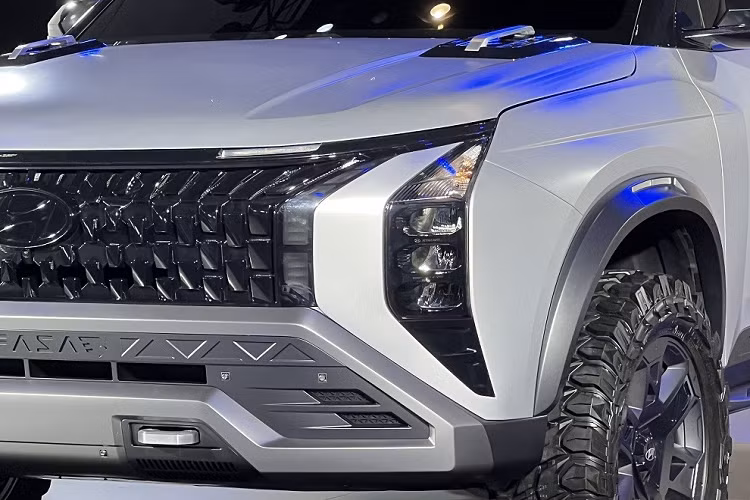 Trong khi đó, dải đèn LED định vị ban ngày được đặt phía trên lưới tản nhiệt, sát với nắp ca-pô. Trên nắp ca-pô còn có thêm 2 tay nắm màu bạc. Bên dưới là cản trước với thiết kế cứng cáp và hầm hố với dòng chữ "Mufasa" dập phía trên hốc gió trung tâm chia thành 4 khoang. Ngoài ra, cản trước còn đi kèm 2 móc cứu hộ được thiết kế lộ thiên.