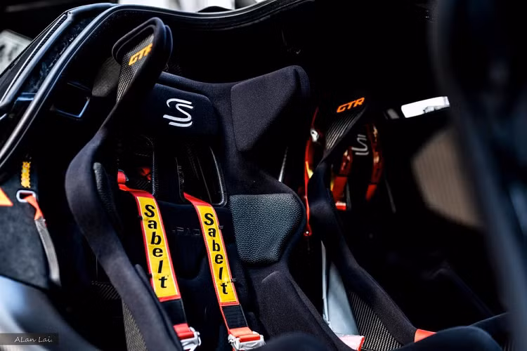 Ngay bản thân vô lăng của xe cũng có thiết kế vô cùng lạ lẫm và thú vị, tiếp đến là màn hình giải trí to lớn, bảng đồng hồ hay cặp ghế đua khi ngồi vào trong cảm giác như mông đã chạm mặt đường mất rồi. Phía bên ghế phụ có thêm 1 bình chữa cháy mini.