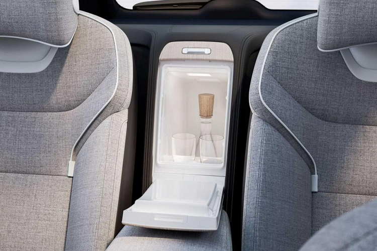 Bệ tì tay trung tâm của Volvo EX90 Excellence 2023 được ốp gỗ tự nhiên và đi kèm chi tiết bằng pha lê Orrefors để điều khiển hệ thống nước hoa trên xe. Xung quanh chi tiết này là những nút chỉnh tính năng sưởi ấm/massage ghế và hệ thống đèn viền nội thất.