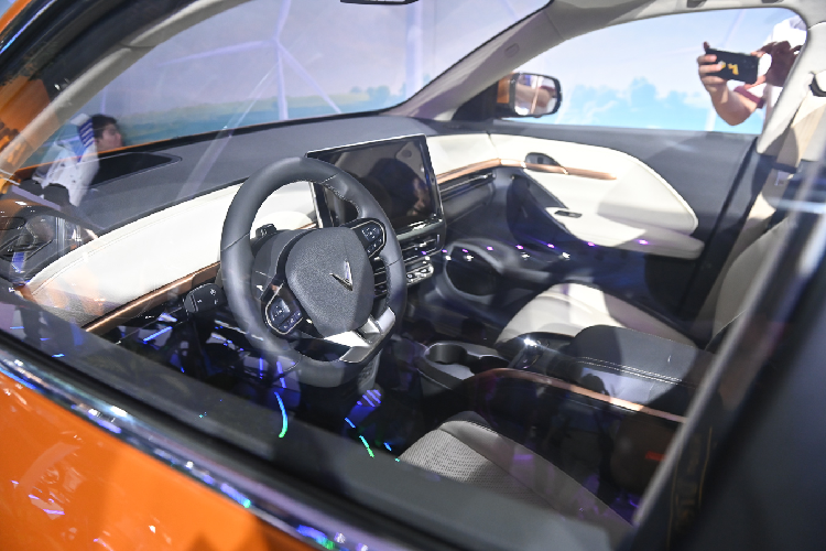 Nội thất của VinFast VF6 nổi bật với màn hình trung tâm cỡ lớn tương tự VF8, vô-lăng D-Cut hiện đại. Đáng chú ý ở những hình ảnh giới thiệu cho thấy, xe được trang bị nút bấm chuyển số nhưng thay vì đặt vào khu vực “yên ngựa” phân tách hàng ghế đầu mà lại được chuyển thành các phím đặt dưới cửa gió điều hòa ở khu vực trung tâm.