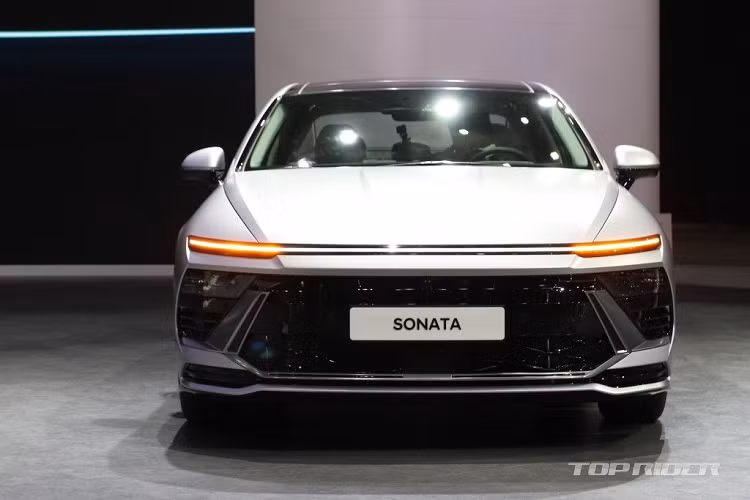 Tiếp đến là lưới tản nhiệt hẹp, tách riêng với hốc gió trung tâm hình chữ nhật phía dưới bằng nẹp màu đen bóng ở giữa. Bên cạnh đó, nắp capo của xe cũng được tạo hình lại với các đường gân nổi thể thao. Logo của hãng cũng đã được chuyển vị trí trung tâm lưới tản nhiệt lên trên nắp ca-pô, tương tự phong cách của Hyundai Accent thế hệ mới.